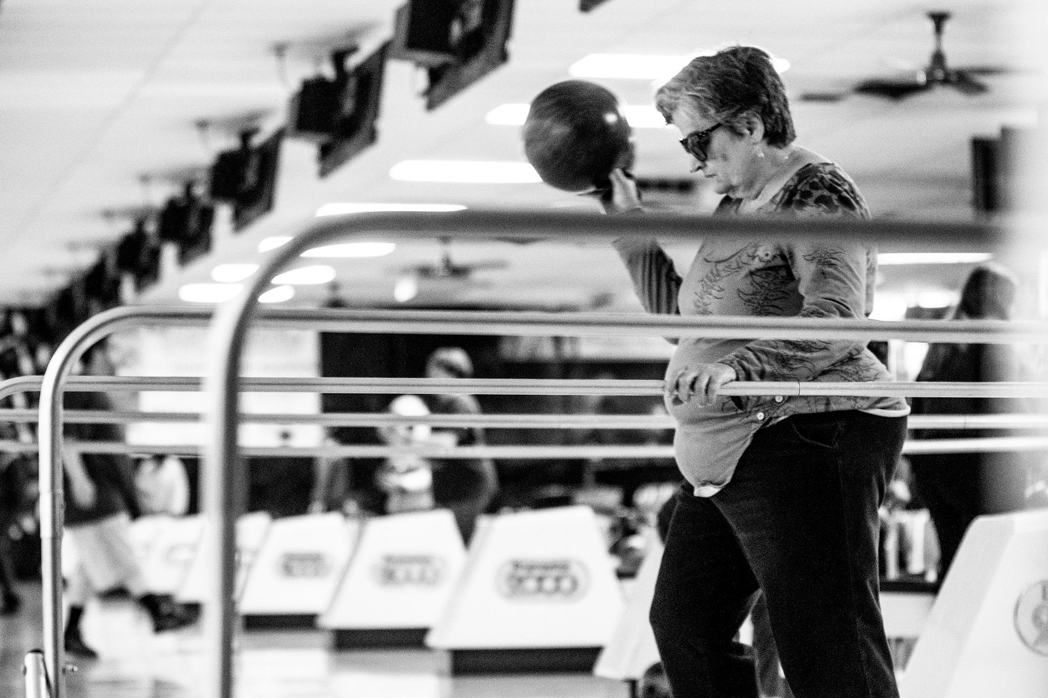 Marlene Kaiser holds her ball up in her right hand, as she moves to throw it, guiding herself with her left hand on the rail. She wears sunglasses and a focused look on her face.