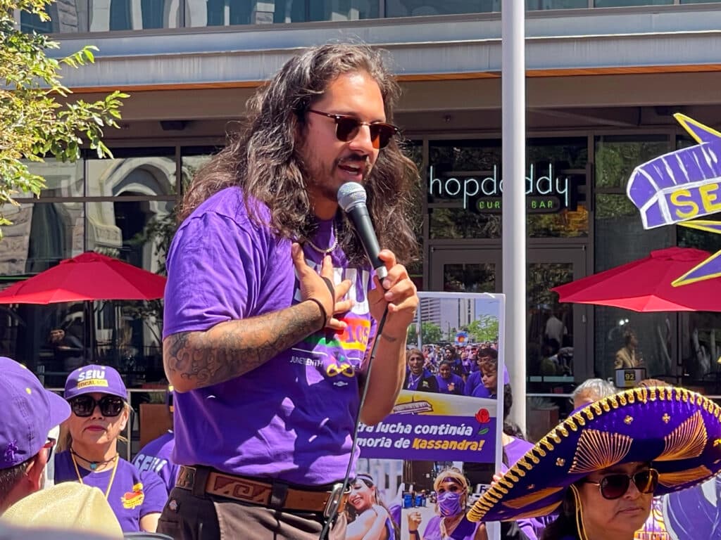 Tim Hernandez speaks into a microphone at a rally for janitors outside Union Station.