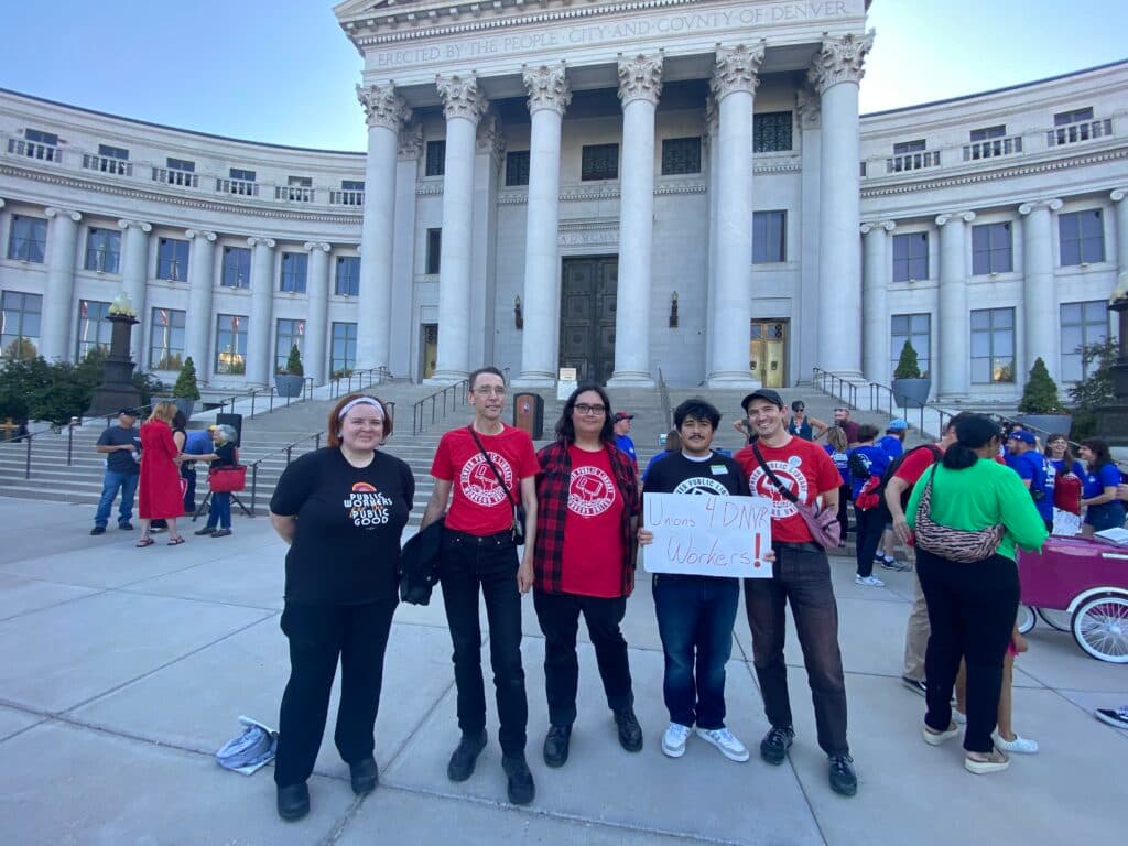 A group of Denver Public Library staff stand in front of the City and County Building in support of unions.