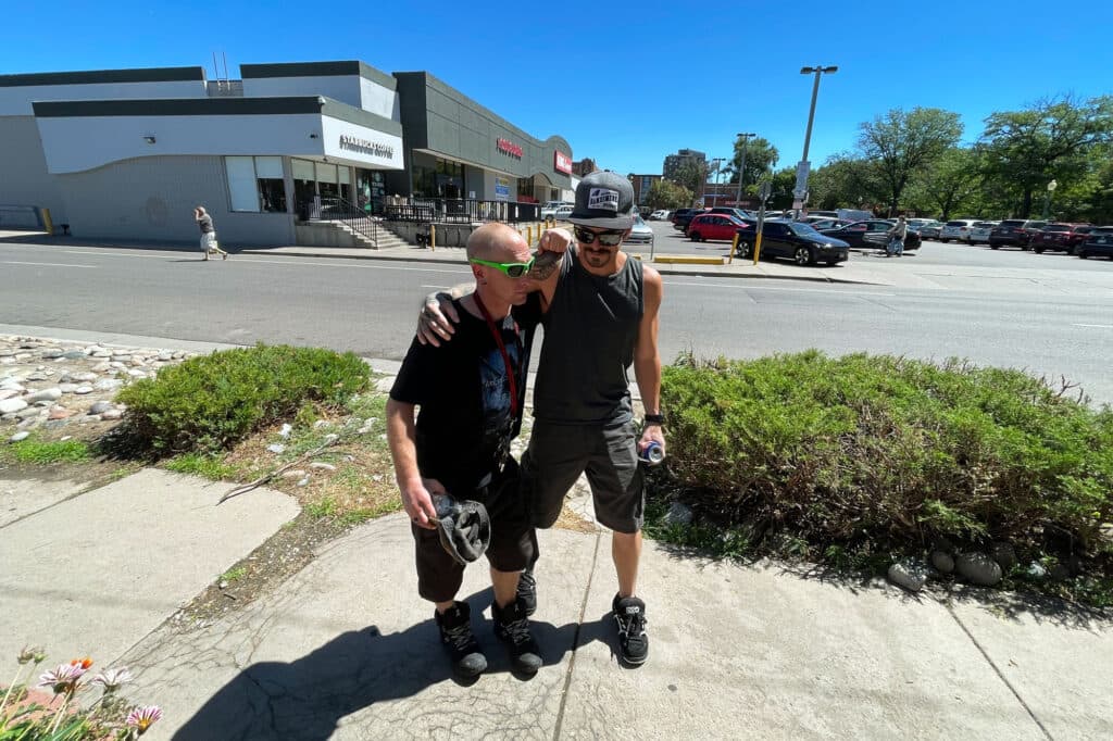 Two men stand in front of a King Soopers grocery store.