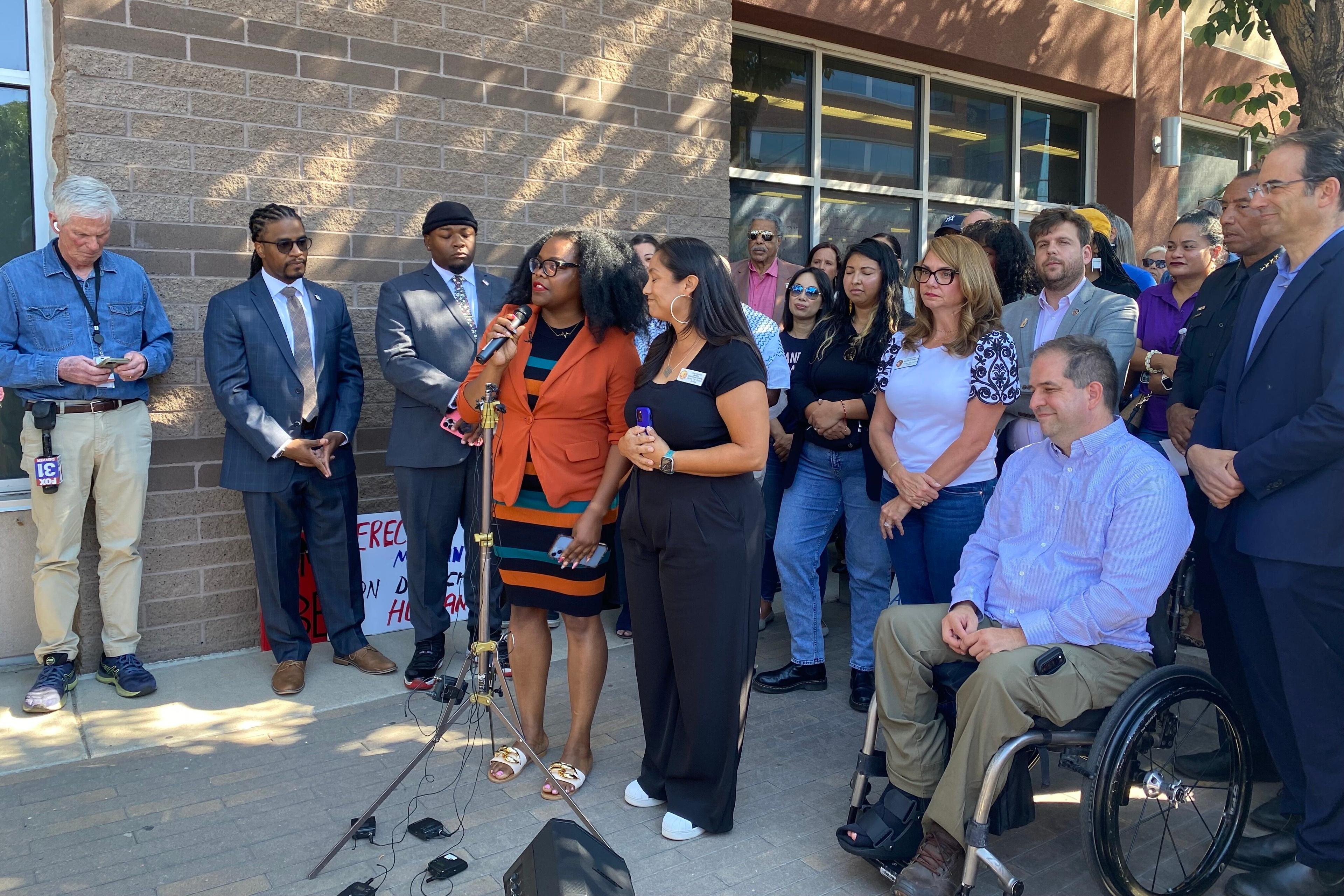 A group of city leaders speak at a press conference.