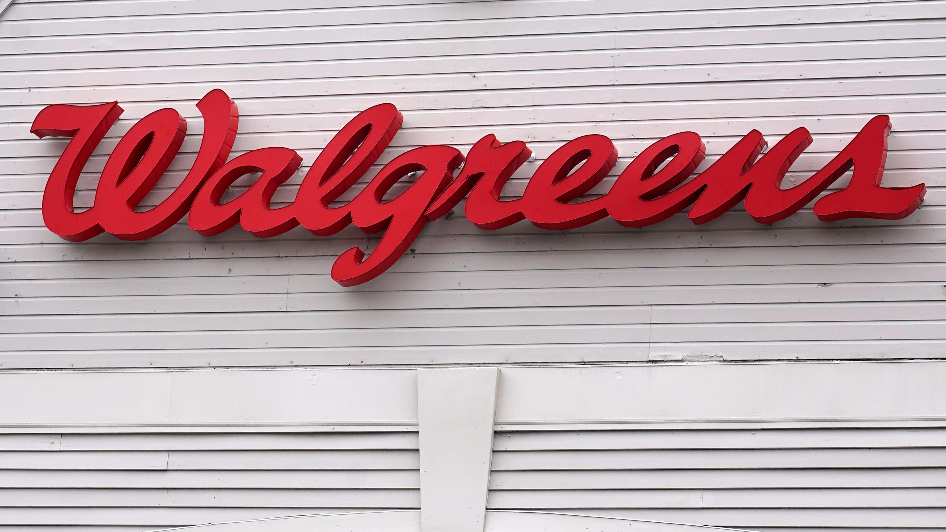 The Walgreens logo on a white wall.