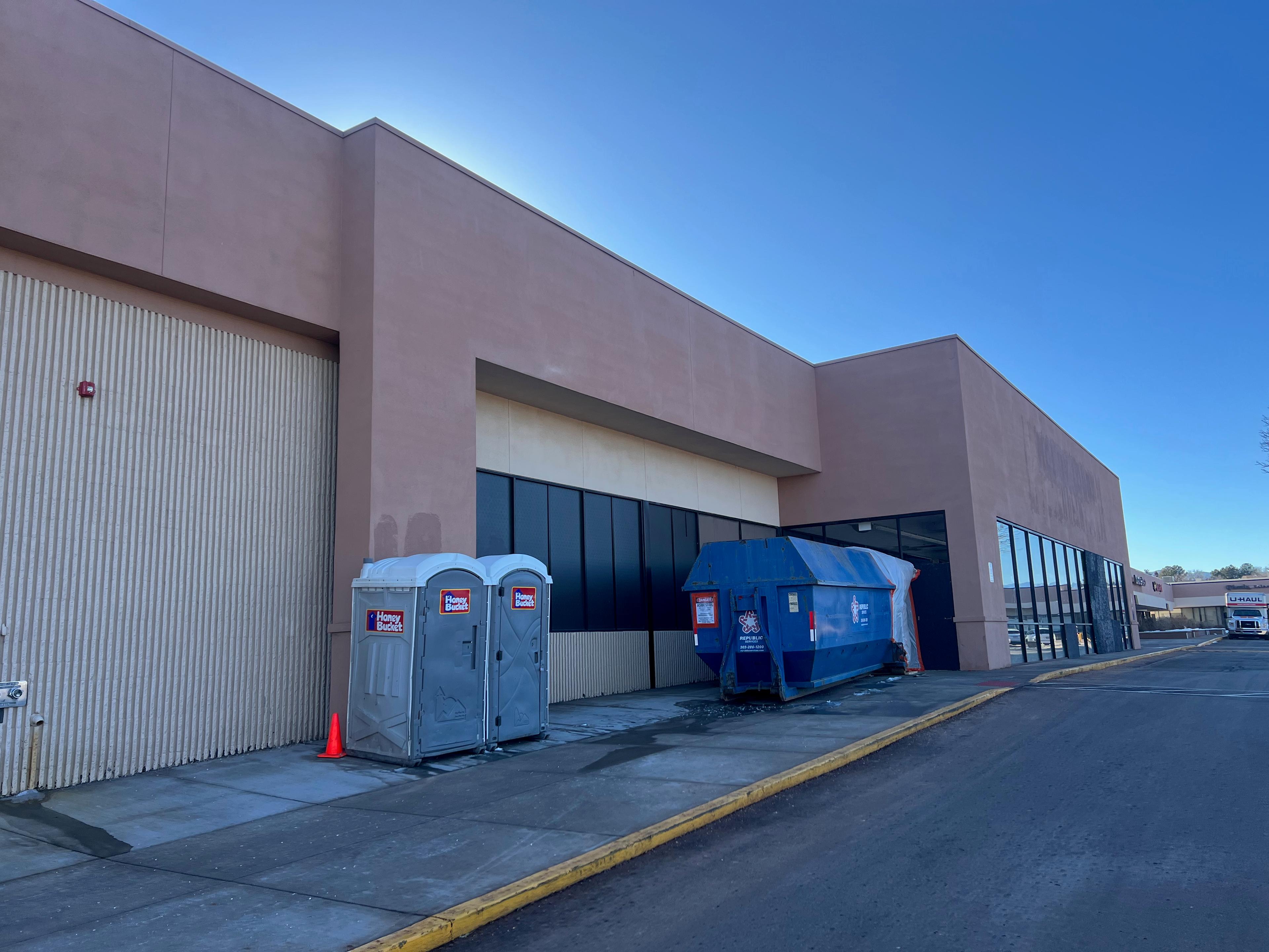 A rubbish container is attached to the door of the former Hobby Lobby that will be demolished to make way for a Whole Foods in Arvada.