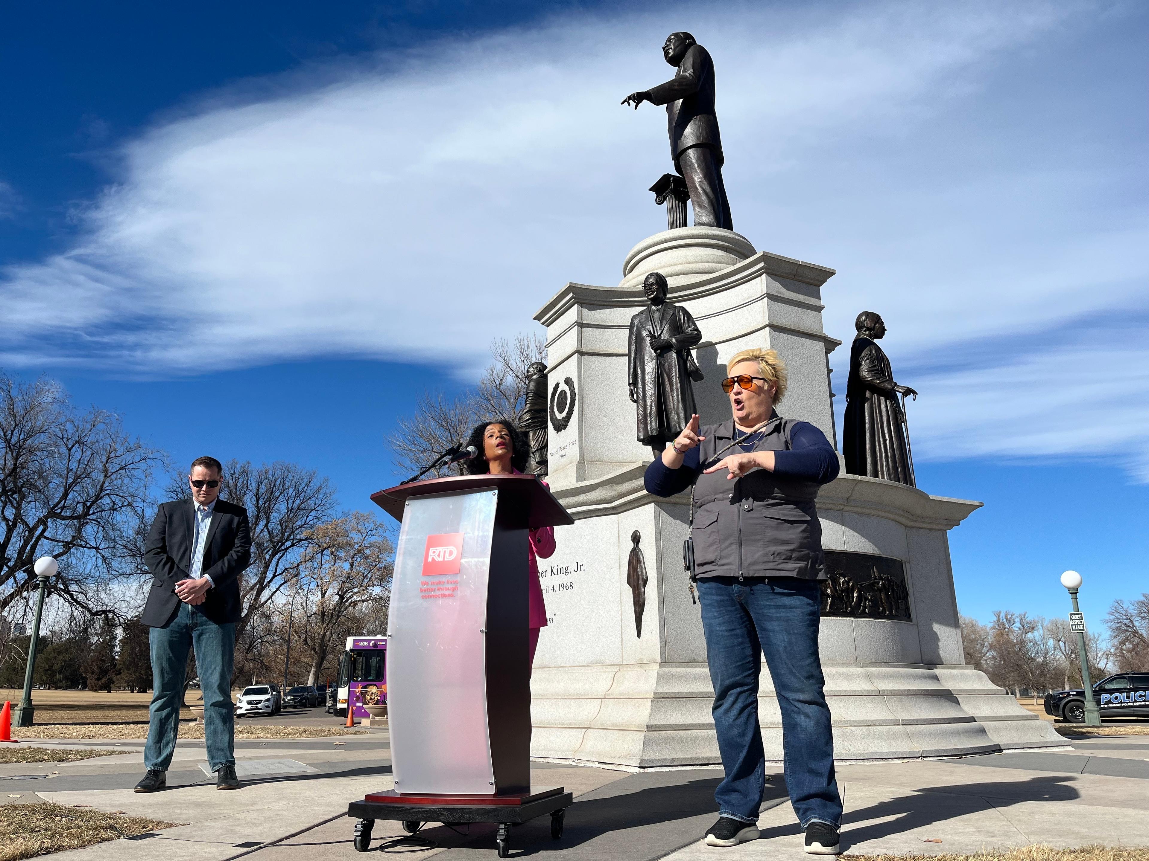 RTD CEO Debra Johnson speaks before statues of Martin Luther King, Jr. and other civil rights leaders.