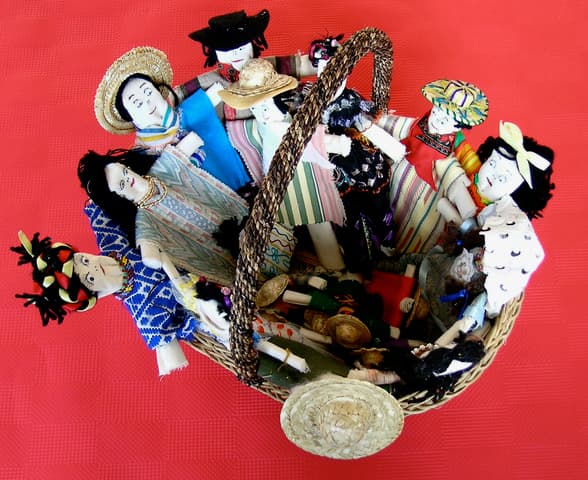 Mexican folk art dolls, crafted from fabric scraps and arranged in a basket.