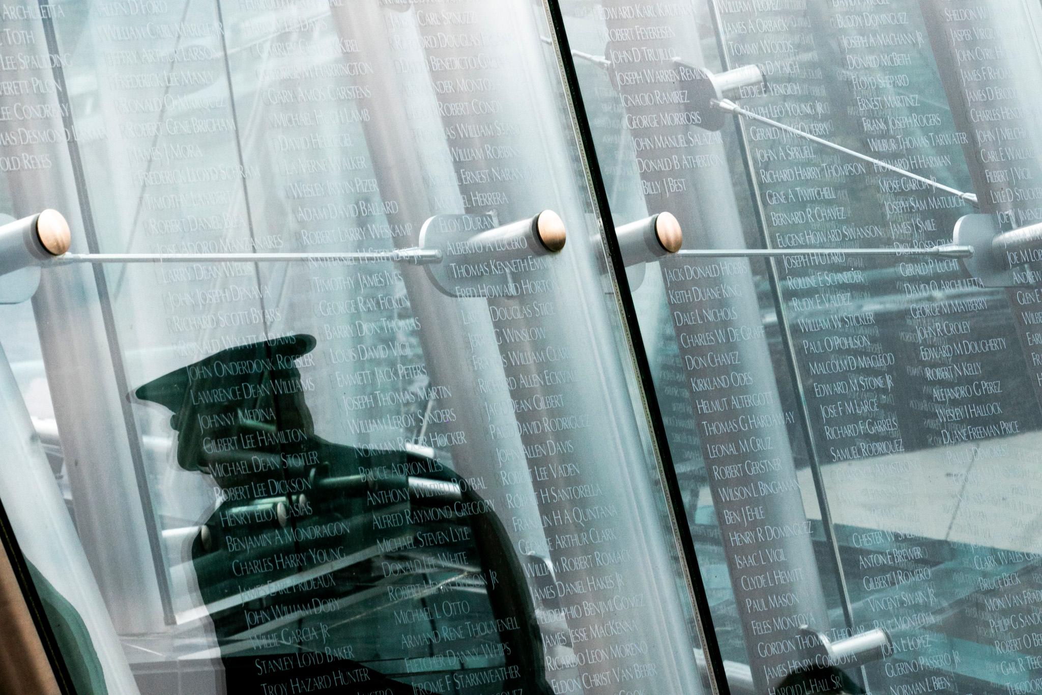 A memorial with a reflection of a soldier on it.