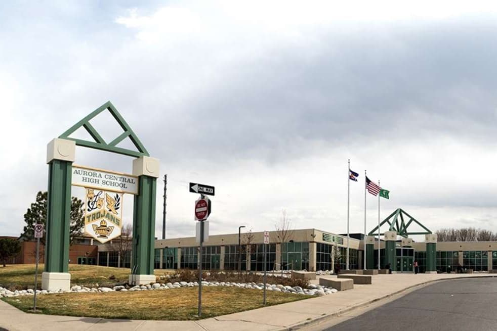 The front of a high school with flags above