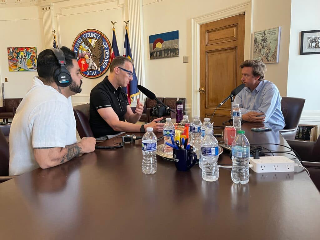 Ryan Warner and Mike Johnston speak to each other in the mayor's office.