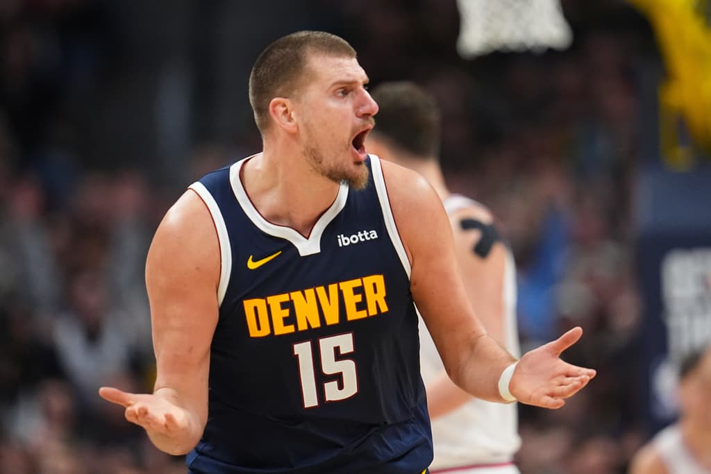 Nikola Jokic gestures with his hands in a frustrated way as he shouts to an unseen figure outside the frame.