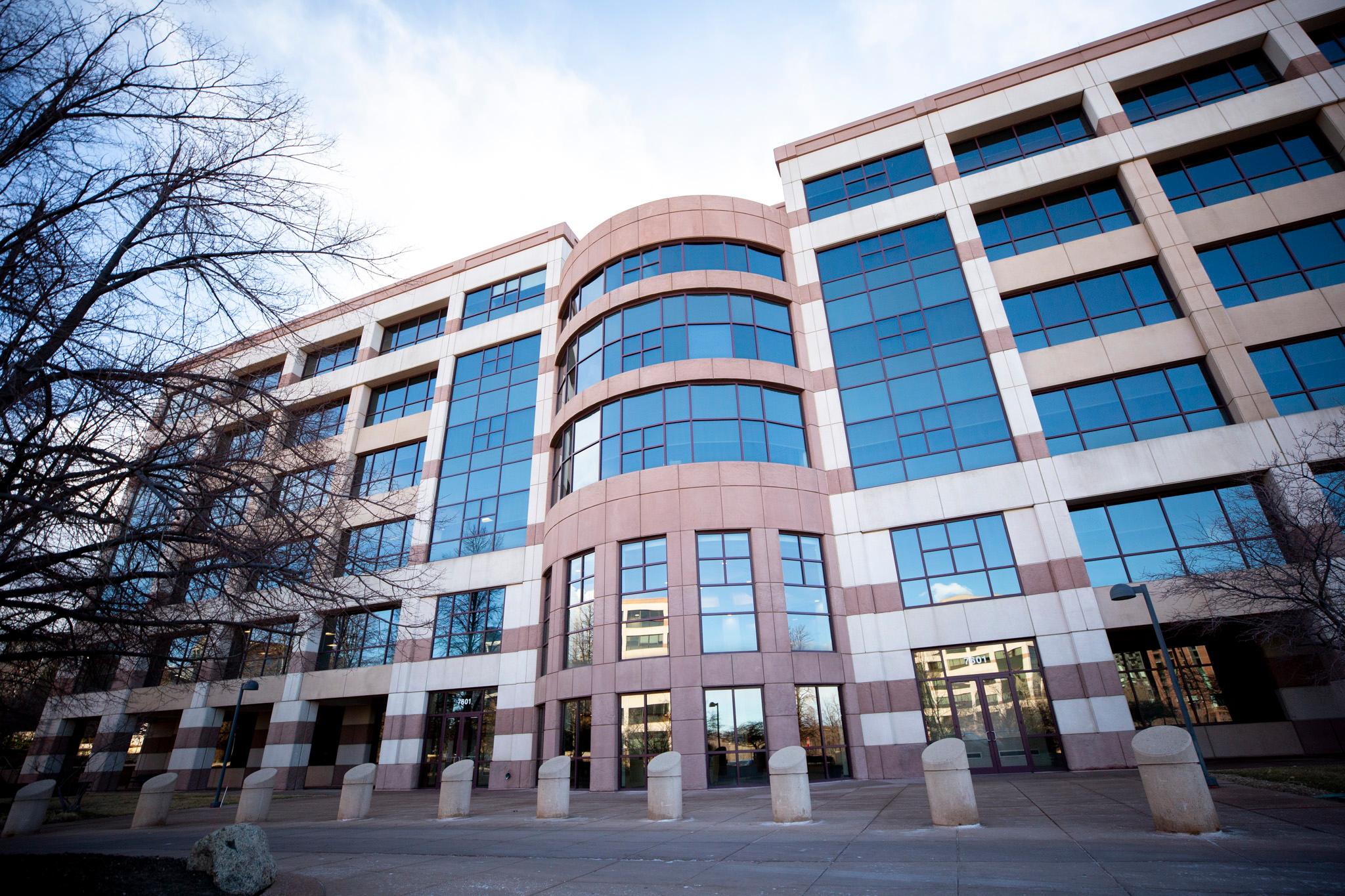 A building of red stone and blue glass windows.