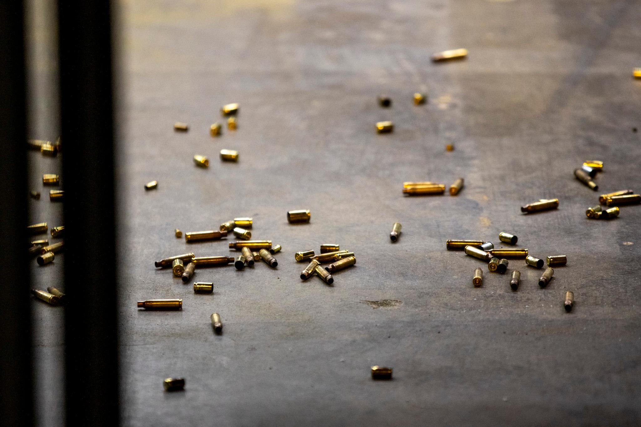 Yellow bullet casings sit on a slate floor.