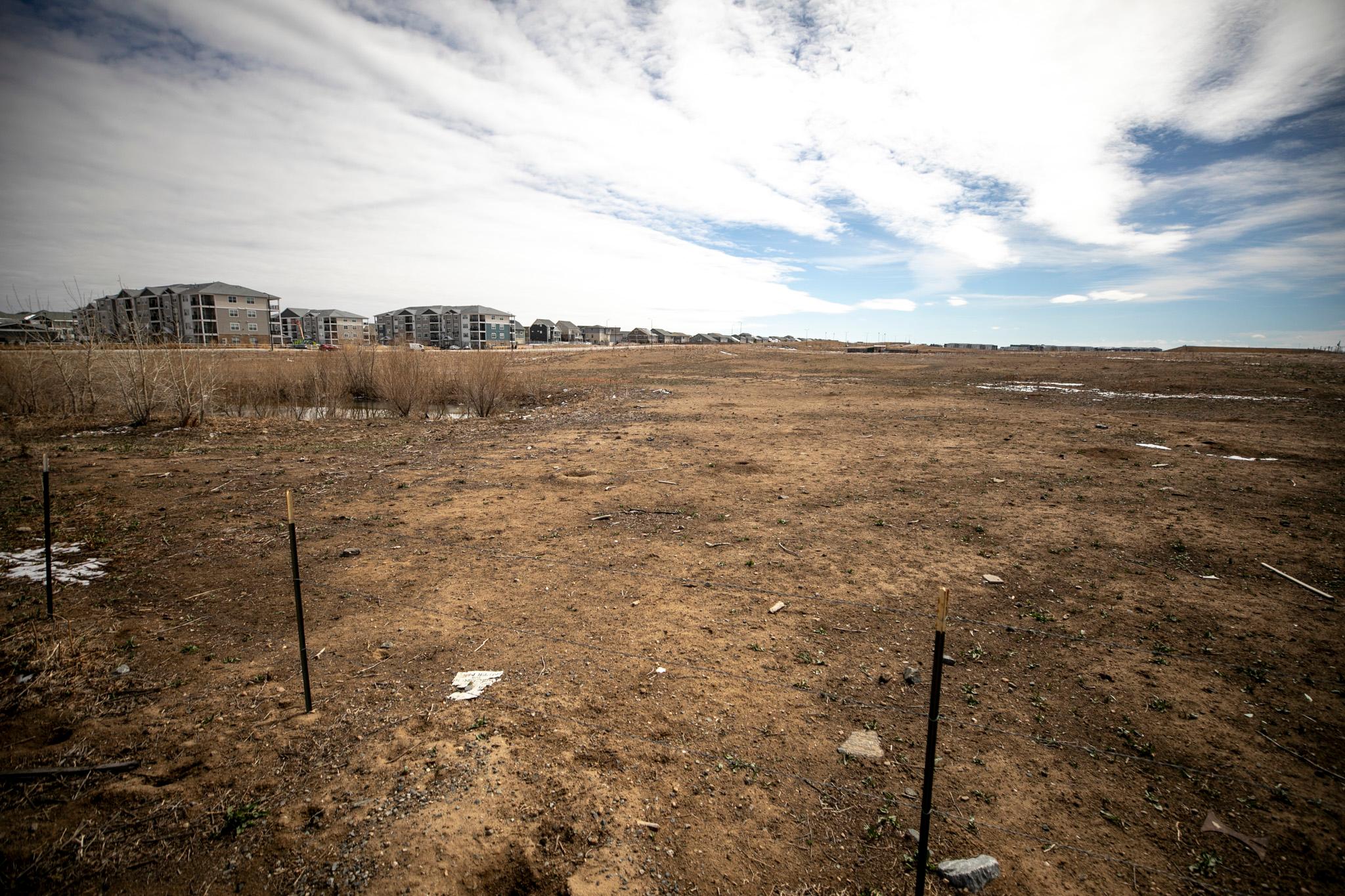 A dirt lot under a cloudy sky.