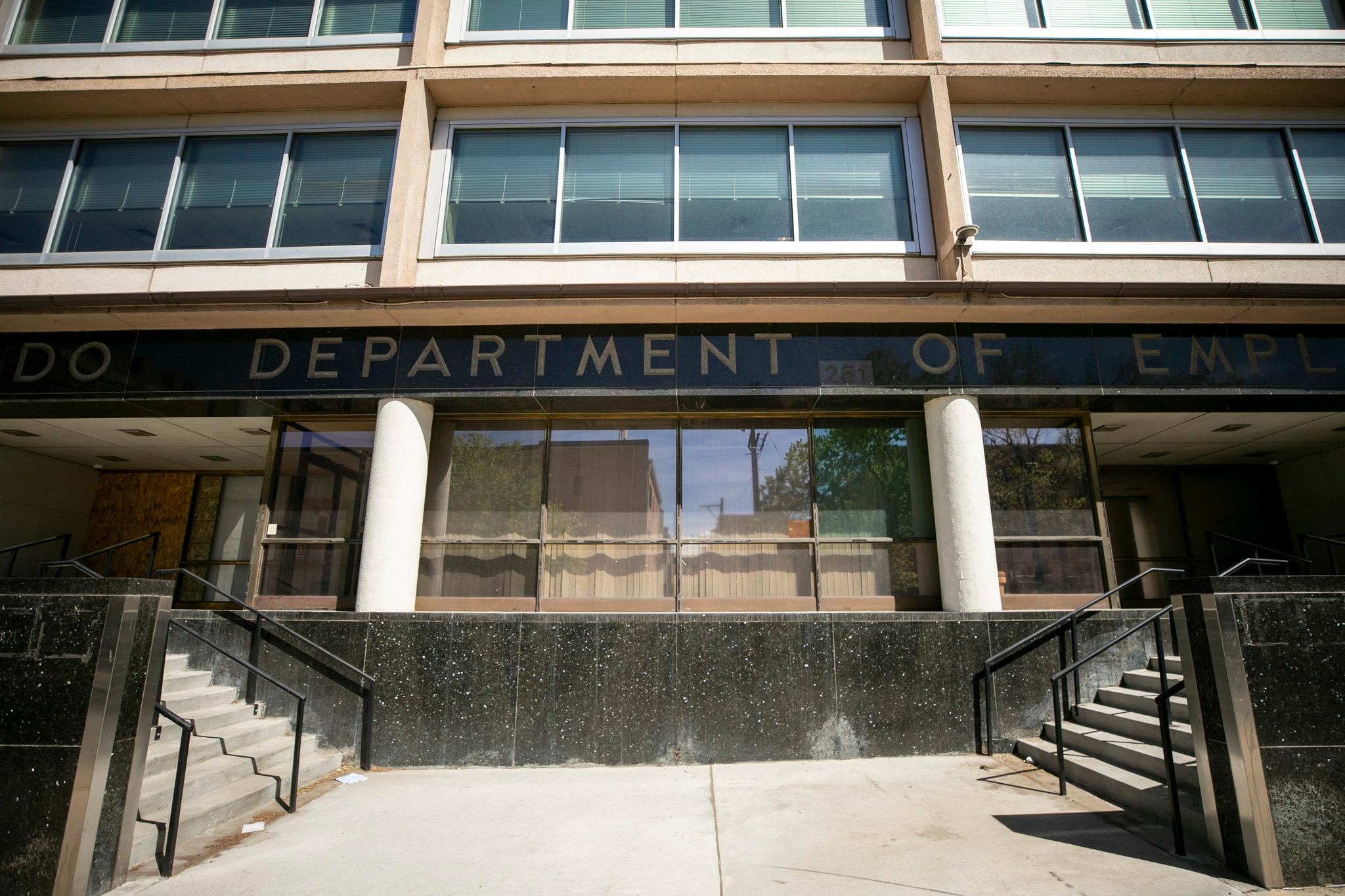 Two staircases lead up to a building with retro lettering that reads "DEPARTMENT." Out of frame, the whole sign reads "Colorado Department of Employment."