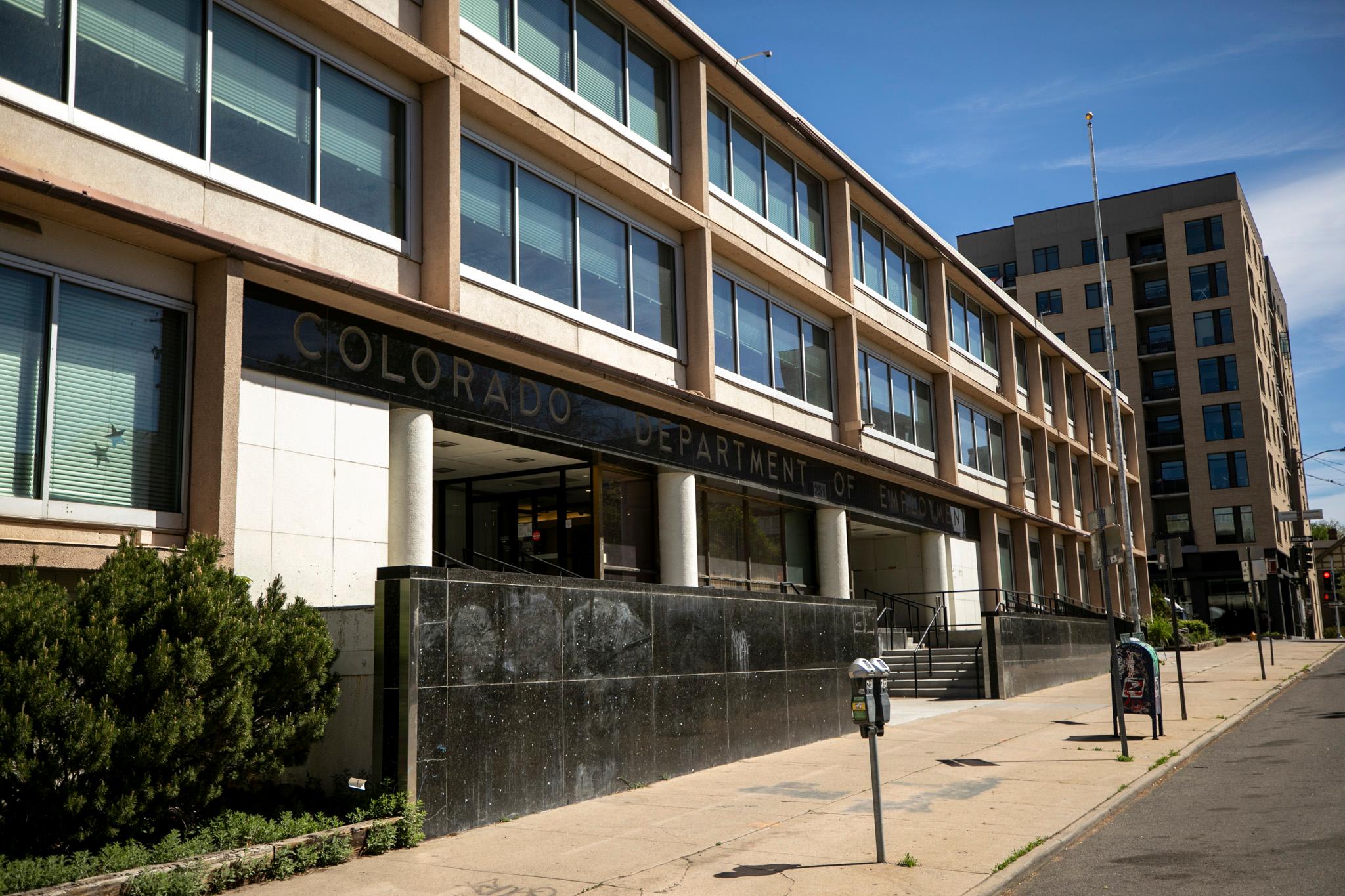 A beige and white building is adorned with retro lettering that reads "COLORADO DEPARTMENT OF EMPLOYMENT."